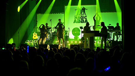 "The Magic of BONEYM Bandmitglieder bei einem Live-Auftritt mit grünen Lichtern"